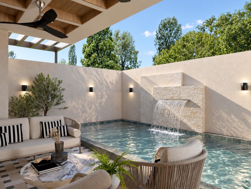 Sala exterior con sofá, butacas de fibra y cascada junto a la piscina